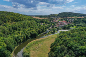 Pohled na lokalitu Zábělá (levá část) z ptačí perspektivy. V horní pravé části zástavba Bukovce, kolem kterého se vine meandr Berounky stáčející se podél Zábělé do spodní levé části snímku. Uprostřed v popředí je viditelná podél řeky louka.